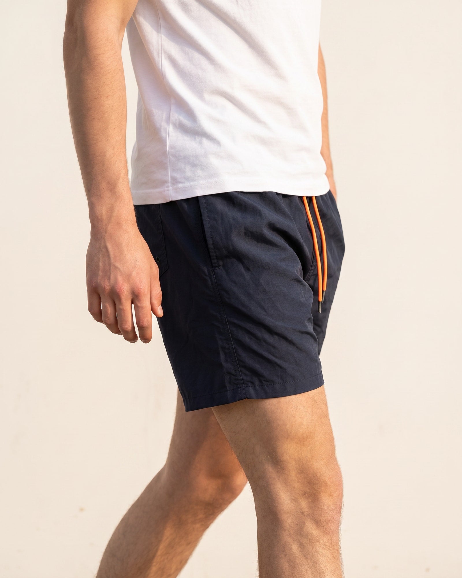Cole Jackson navy shorts and white tee worn mid-stride